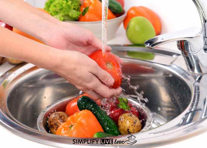 woman rinsing peppers after homemade vegetable wash