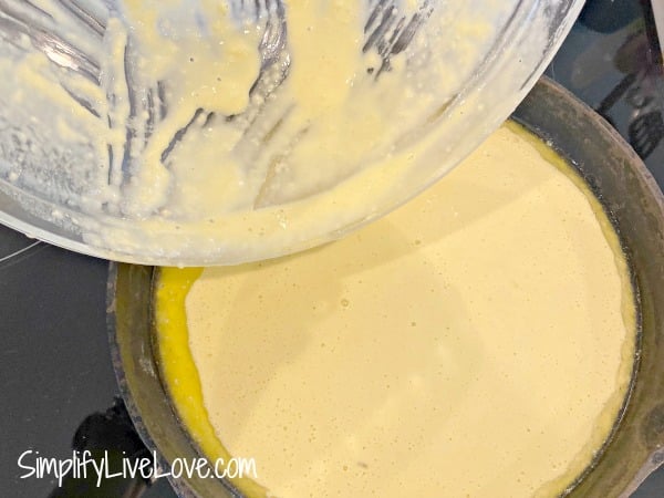 pouring the german pancake batter into the pan