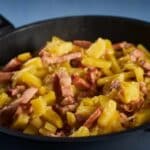 fried potatoes and ham in a cast iron skillet