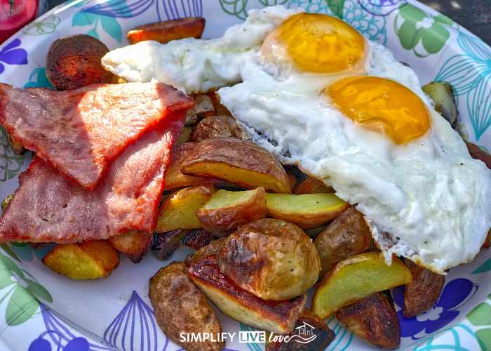 fried potatoes, ham, and eggs on a platter