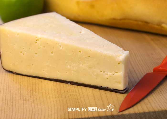 asiago cheese on wooden counter with red knife
