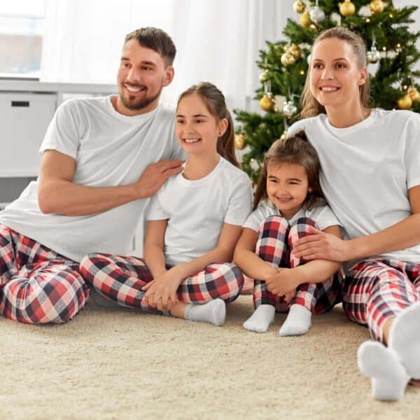 mom and dad with kids in front of christmas tree wearing matching pajamas