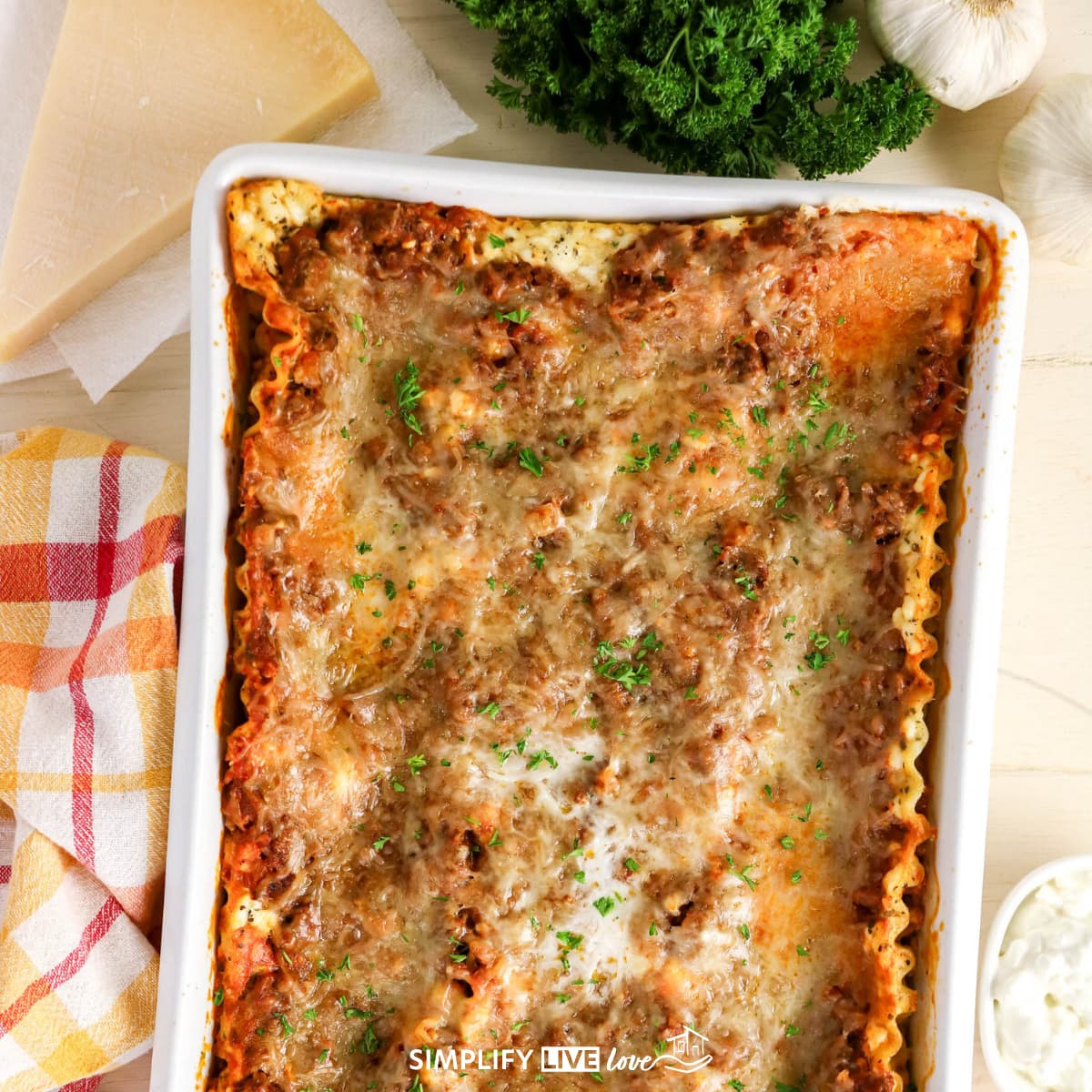cottage-cheese-lasagna-baked-overhead Baked cottage cheese lasagna in a white 9x13 dish topped with melted cheese and fresh parsley