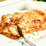 piece of lasagna on a plate with a fork