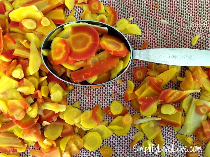 measuring cup with blanched carrots on a towel