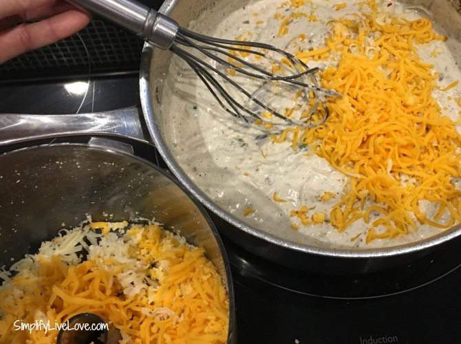 Woman's hand holding a whisk in a saucepan to make jalapeno dip with real cheddar cheese