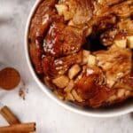 caramel apple monkey bread with cinnamon sticks on counter