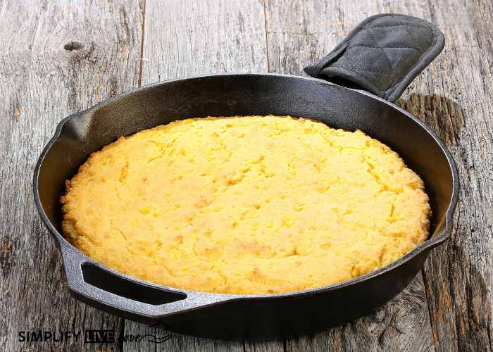 yellow southern cornbread baked in a cast iron skillet on a wooden table
