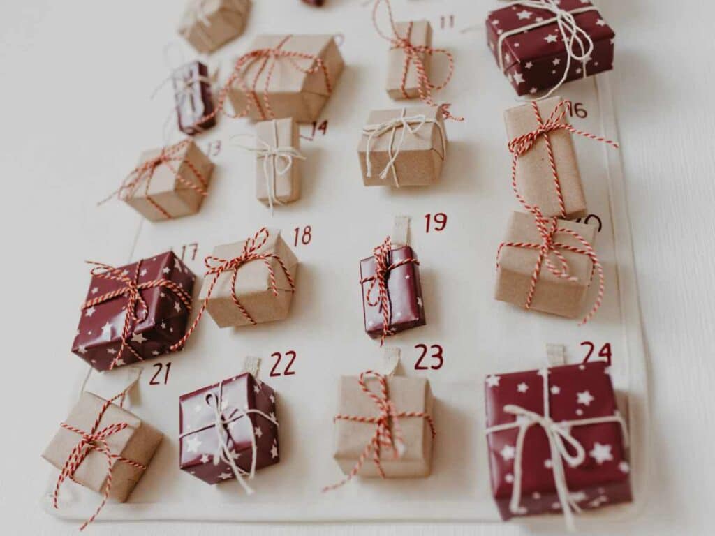 homemade advent calendar with small gift wrapped boxes tied with string and numbered