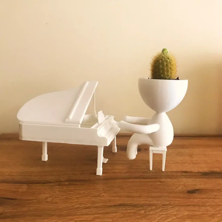 3D printed piano planter of a piano and man where his head is a planter