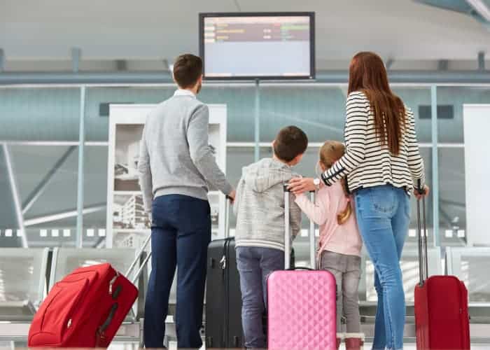 family looking at airport monitor