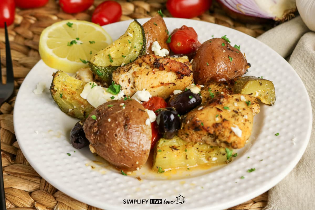 plated chicken, zucchini, tomato, olives with a slice of lemon