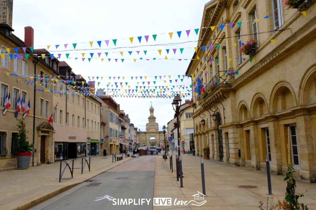 bunting lined French street with a triumphal arch in the background